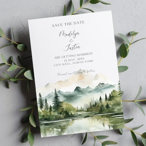 Puede incluir: Tarjeta de guardar la fecha con una ilustraci&oacute;n de acuarela de una cordillera, un lago y &aacute;rboles. El texto dice "Save the Date Madelyn & Justin Are Getting Married! 12 May, 2024 City Hall, North York Formal invitation to follow."