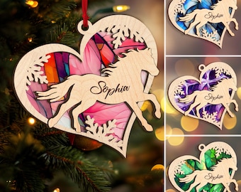 May include: A wooden heart-shaped ornament with a stained glass design and a horse silhouette. The ornament is personalized with the name "Sophia".