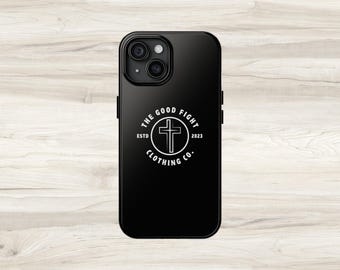 Op de afbeelding: Zwarte telefoonhoes met een wit rond logo met de tekst "The Good Fight Clothing Co." met een kruis in de cirkel. Het logo heeft ook de tekst "Estd 2023".