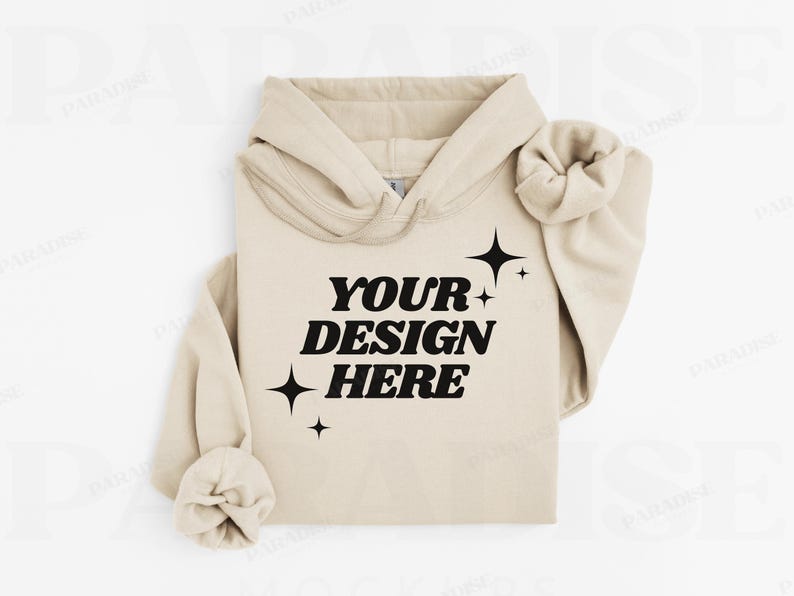 May include: A beige hoodie with the text "YOUR DESIGN HERE" in bold black letters, accented by starburst graphics. The hoodie features a drawstring hood and cuffed sleeves, perfect for showcasing custom designs.