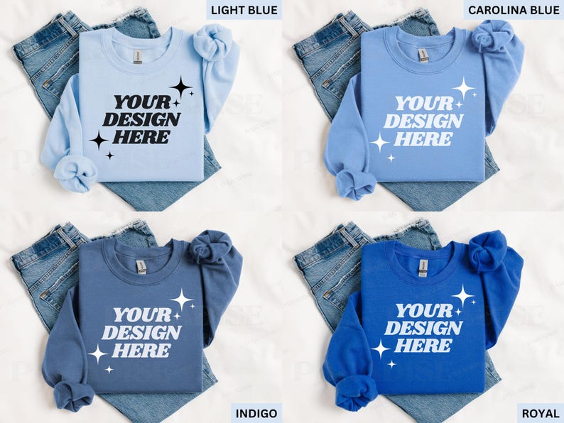 May include: Four crewneck sweatshirts in light blue, Carolina blue, indigo, and royal blue, each with the text "YOUR DESIGN HERE" in white. The sweatshirts are displayed on top of folded denim jeans.