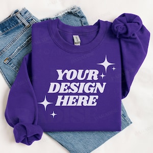 May include: Purple sweatshirt with the text "YOUR DESIGN HERE" in white, with small white stars around the text.