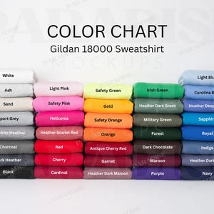 Puede incluir: Una carta de colores para sudaderas Gildan 18000, que muestra cinco pilas verticales de prendas dobladas en varios tonos, incluyendo blanco, ceniza, arena, gris, rosa, rojo, verde, naranja, amarillo, marrón, morado y azul con etiquetas.