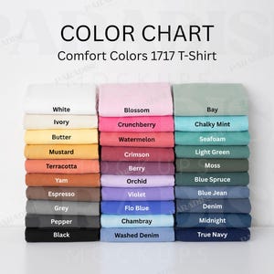 May include: A color chart for Comfort Colors 1717 T-Shirts featuring three vertical columns of folded fabric swatches in various shades including white, pink, green, yellow, orange, brown, grey, black, purple, and blue with printed labels.
