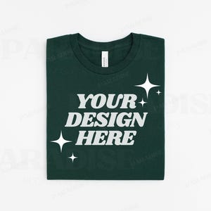 May include: A dark green t-shirt with the text "YOUR DESIGN HERE" in white lettering and a few white stars.