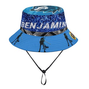 May include: Blue bucket hat with a wolf graphic and the name "BENJAMIN" printed on the front. The hat has a black drawstring.