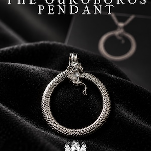 May include: A silver-toned Ouroboros pendant featuring a snake biting its own tail to form a circular shape with detailed scales and a visible head. The text THE OUROBOROS PENDANT is displayed at the top, and a small skull emblem is at the bottom.
