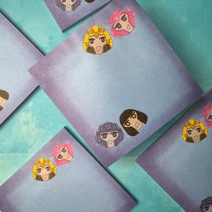 May include: A set of colorful sticky notes with cartoon characters on them. The notes are blue with a galaxy-like pattern. The characters are yellow, pink, and purple and have different expressions.