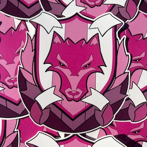 May include: Multiple pink and white stickers with a wolf design. The wolf is in a shield with arrows pointing out of the shield.