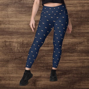 May include: Navy blue leggings with a repeating pattern of small gold dog silhouettes.