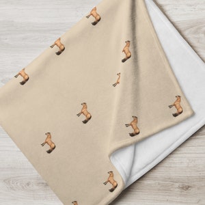Può includere: Una coperta per cavalli color beige e marrone con un motivo ripetuto di un cavallo marrone in piedi sulle zampe posteriori. La coperta è realizzata in pile morbido ed è perfetta per mantenere il tuo cavallo al caldo e comodo.