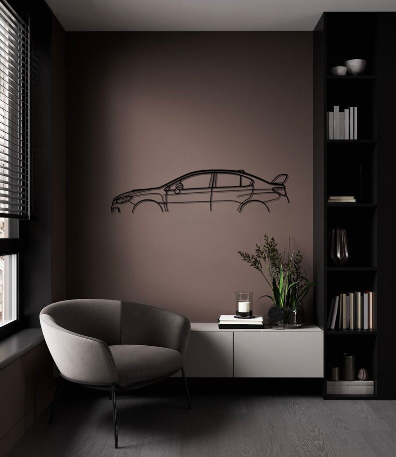 May include: A black metal car outline wall art. The artwork is mounted on a brown wall in a modern living room. The room features a grey armchair, a white and grey cabinet, and a black bookshelf.