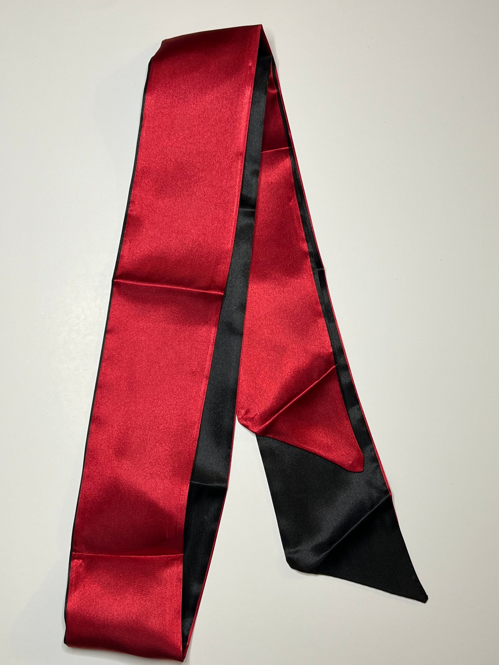 Erotic silk blindfold in red and black, perfect for beginner bondage and restraint sex
