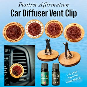 Op de afbeelding: Houten autoluchtverfrisserclips met positieve affirmaties, waaronder "Ik ben mooi, ik ben sterk, ik ben de liefde waard", "Ik ben mooi" en "Houd van jezelf". De clips worden getoond met twee kleine flesjes etherische olie.
