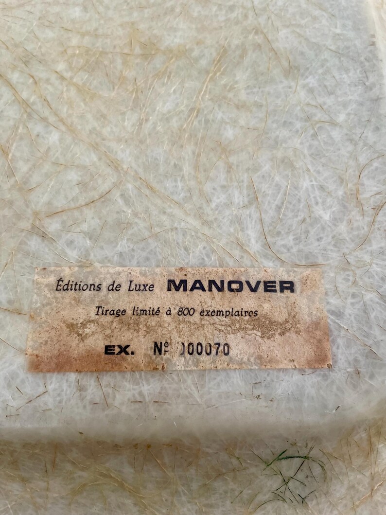 May include: A close-up of a white label with the text "Editions de Luxe MANOVER Tirage limit&eacute; &agrave; 800 exemplaires EX. N&deg; 00070" printed on it.