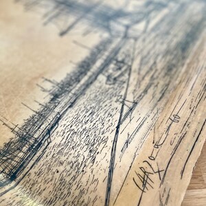 May include: A black and white drawing on a beige paper background. The drawing is of a city skyline with buildings and streets. The drawing is signed "HARPER" in the bottom right corner.