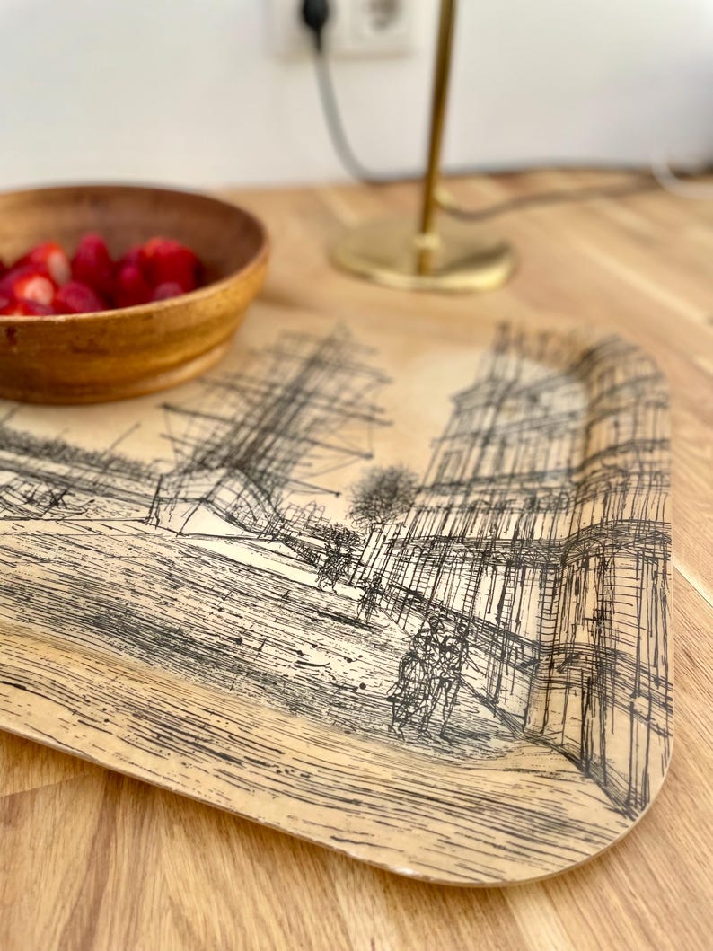 May include: A rectangular tray with a beige background and a black and white line drawing of a city scene. The tray has a wood-grain texture.