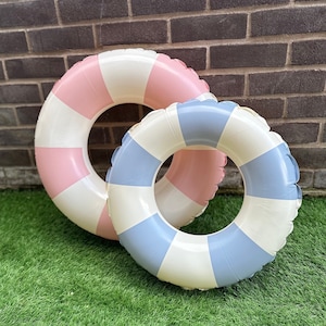 May include: Two inflatable pool rings, one pink and white with a striped pattern and one blue and white with a striped pattern.
