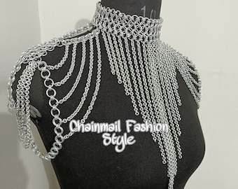 May include: Silver chainmail shoulder piece with a fringe design. The piece is made of interlocking metal rings and has a delicate, flowing look.  Chainmail Fashion Style.