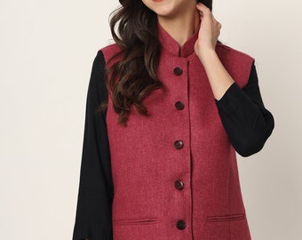 May include: A burgundy sleeveless vest with a mandarin collar and button closure. The vest has two pockets and a textured fabric.