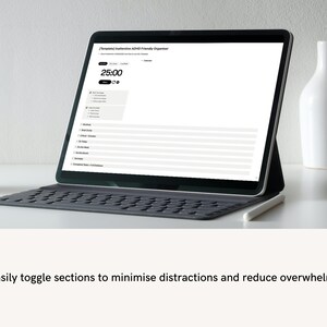 Pode incluir: Um laptop preto com uma tela branca exibindo um planejador digital com o texto "Templated Intuitive ADHD Friendly Organizer". A tela mostra um cron&ocirc;metro configurado para 25:00. O laptop est&aacute; em uma mesa branca com um vaso de cer&acirc;mica branco e uma caneca branca.