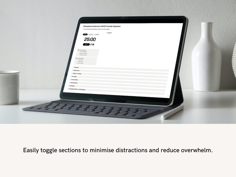 Pode incluir: Um laptop preto com uma tela branca exibindo um planejador digital com o texto "Templated Intuitive ADHD Friendly Organizer". A tela mostra um cron&ocirc;metro configurado para 25:00. O laptop est&aacute; em uma mesa branca com um vaso de cer&acirc;mica branco e uma caneca branca.