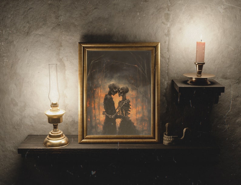 May include: A framed artwork depicting two skeletons embracing in a dark forest setting. The artwork is displayed on a wooden shelf with a lit oil lamp and a candle on either side.