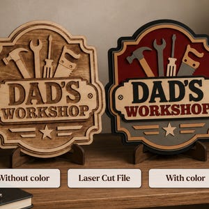 May include: Two layered wooden signs featuring the text DAD'S WORKSHOP. One sign is natural wood with engraved tool icons including a hammer, wrench, screwdriver, and saw. The second sign features a red, black, and grey color scheme with the same design.
