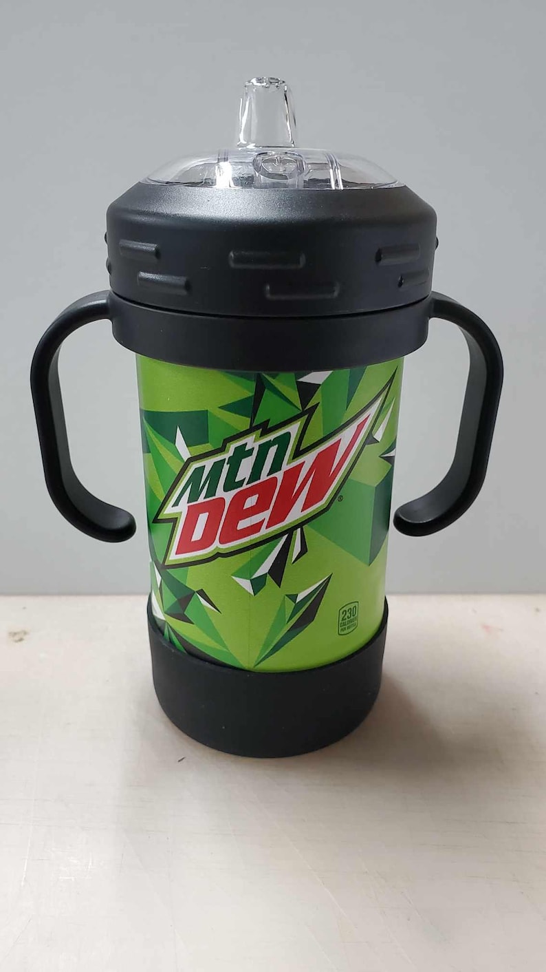 May include: A black and green Mountain Dew branded sippy cup with two handles. The cup has a clear plastic lid with a spout.