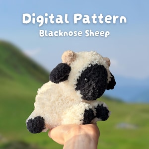 Pode incluir: Um brinquedo de crochê Blacknose Sheep com um corpo branco e fofo, rosto, orelhas e pernas pretas. A imagem inclui o texto "Digital Pattern Blacknose Sheep". O fundo é uma cena externa desfocada. O brinquedo é segurado em uma mão.