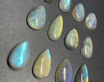 Puede incluir: Doce cabujones de labradorita en forma de lágrima en varios tonos de gris, azul y amarillo.