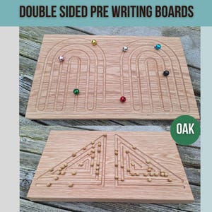 May include: Double-sided wooden pre-writing board made of oak. One side features a rainbow design with grooves for marbles. The other side has a triangular maze with small wooden beads.