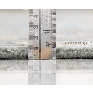 May include: Close-up of a gray rug with a ruler measuring the pile height at 1/2 inch. The text "DreamrugsIndia" is visible in the background.