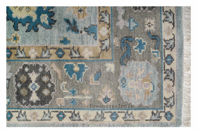 May include: A blue and gray patterned rug with a floral design. The rug has a fringe border.