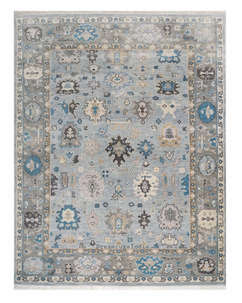 May include: A blue and gray patterned rug with a border of intricate designs. The rug has a faded, vintage look and features a central medallion.