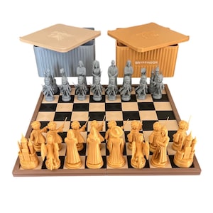 May include: A themed chess set with grey and tan pieces on a chequered board. The set includes two storage boxes, one with the word "Gryffindor" on it. The chess pieces are designed with a fantasy theme.