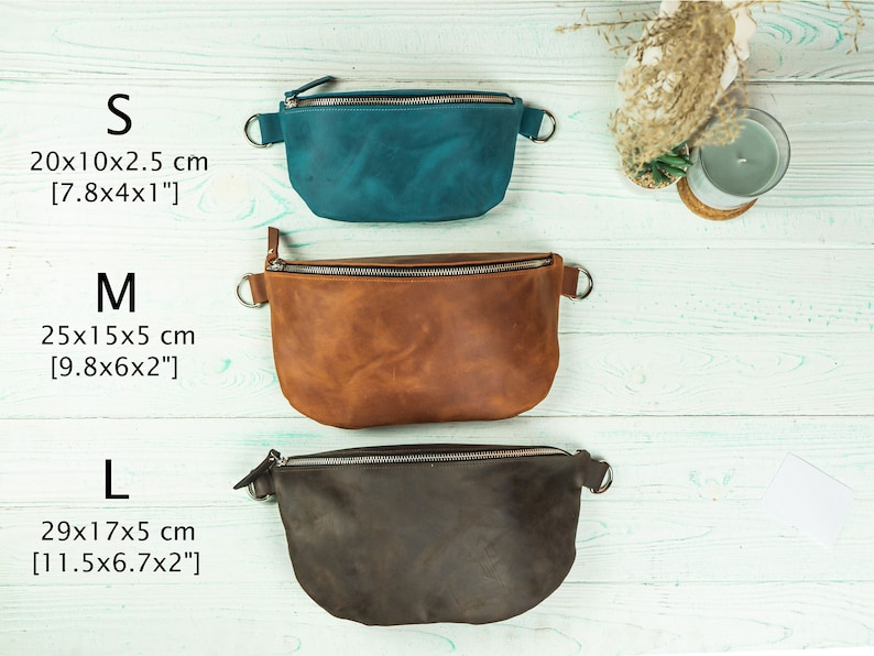 K&ouml;nnte beinhalten: Drei Leder-Bauchtaschen in den Farben T&uuml;rkis, Braun und Dunkelbraun, jeweils mit Rei&szlig;verschluss und Metallring an jeder Seite. Gr&ouml;&szlig;en: S (20x10x2,5 cm), M (25x15x5 cm), L (29x17x5 cm).