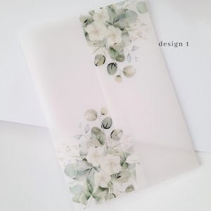 Könnte beinhalten: Ein durchscheinender Umschlag mit floralem Design. Das Design zeigt weiße Blumen und grüne Blätter. Der Text "design 1" ist schwarz auf der rechten Seite des Umschlags aufgedruckt. Der Umschlag befindet sich auf weißem Hintergrund.