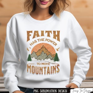 Könnte beinhalten: Weißes Sweatshirt mit einem Grafikdesign im Vintage-Stil, auf dem "Glaube hat die Kraft, Berge zu versetzen" steht. Die Grafik zeigt einen Sonnenuntergang mit Bergen und Vögeln.