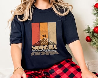 May include: A black t-shirt with a vintage-style graphic design featuring a mountain range, a sun, and the text "HIS MERCIES Are New Every Morning".