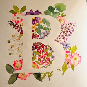 May include: Watercolour painting of the letter "B" created using a range of flowers and leaves in shades of pink, purple, white, and green.