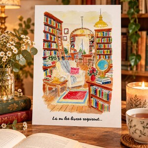 Może przedstawiać: Akwarelowy wydruk przedstawiający wnętrze przytulnej biblioteki z regałami od podłogi do sufitu, wygodnym fotelem, globusem i czerwonym dywanem. Tekst "L&agrave; ou les livres respirent..." jest nadrukowany czarną czcionką na dole kartki.
