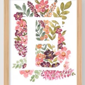 May include: Watercolor floral art print of the letter "E" in a wooden frame. The letter is filled with pink, purple, and orange flowers and green leaves. The frame is a light brown color.