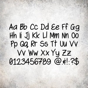 May include: A handwritten alphabet and numbers in black ink on a gray textured background. The letters are in uppercase and lowercase. The numbers are 0 through 9. The symbols include the at symbol, euro symbol, exclamation point, colon, and dollar sign.