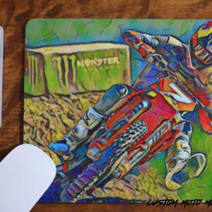 May include: A colorful, abstract illustration of a motocross rider in mid-air, jumping over a Monster Energy drink can. The rider is wearing a helmet and goggles, and the motorcycle is red and black.