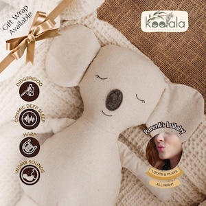 Può includere: Un peluche a forma di koala beige con gli occhi chiusi e un naso grigio scuro. Il giocattolo ha grandi orecchie ed è appoggiato su una coperta color crema. L'immagine include il testo "Gift Wrap Available", "Didgeridoo", "Cosmic Deep Sleep", "Harp", "Womb Sounds", "Parent's Lullaby", "Loops & Plays All Night".