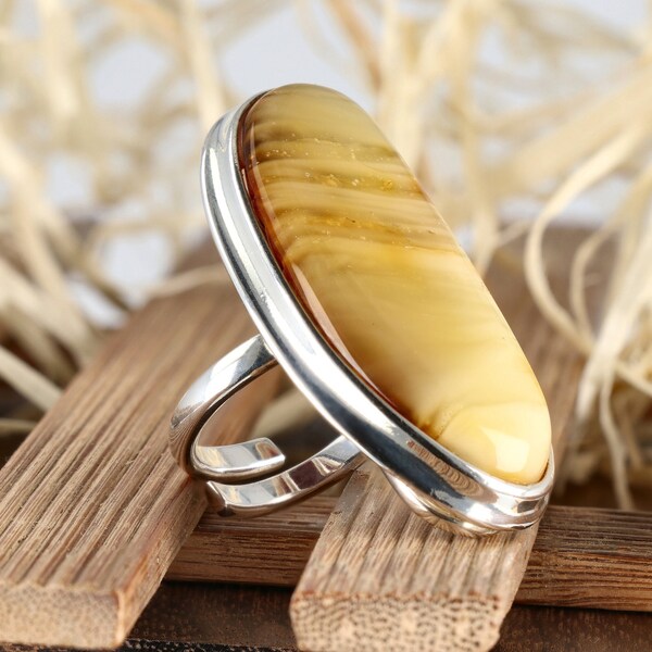 Duży srebrny pierścionek z jasnym bursztynem w paski, regulowany, podłużny