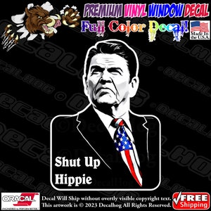 May include: A black and white illustration of a man with a serious expression wearing a suit and tie. The tie is an American flag. The text "Shut Up Hippie" is below the image.