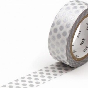 Könnte beinhalten: Eine Rolle Washi-Tape mit einem Muster aus grauen Punkten auf weißem Hintergrund. Das Klebeband ist mit den Buchstaben "mt" in Schwarz beschriftet. Dieses dekorative Klebeband eignet sich für Bastelarbeiten, Scrapbooking und zum Hinzufügen eines stilvollen Elements zu verschiedenen Projekten.