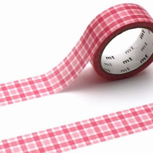Könnte beinhalten: Eine Rolle Washi-Tape mit rot-weißem Vichy-Muster. Das Klebeband ist teilweise abgerollt und zeigt das Muster sowie den Markennamen "mt" auf dem Kern. Ideal zum Basteln, Scrapbooking und für dekorative Zwecke.